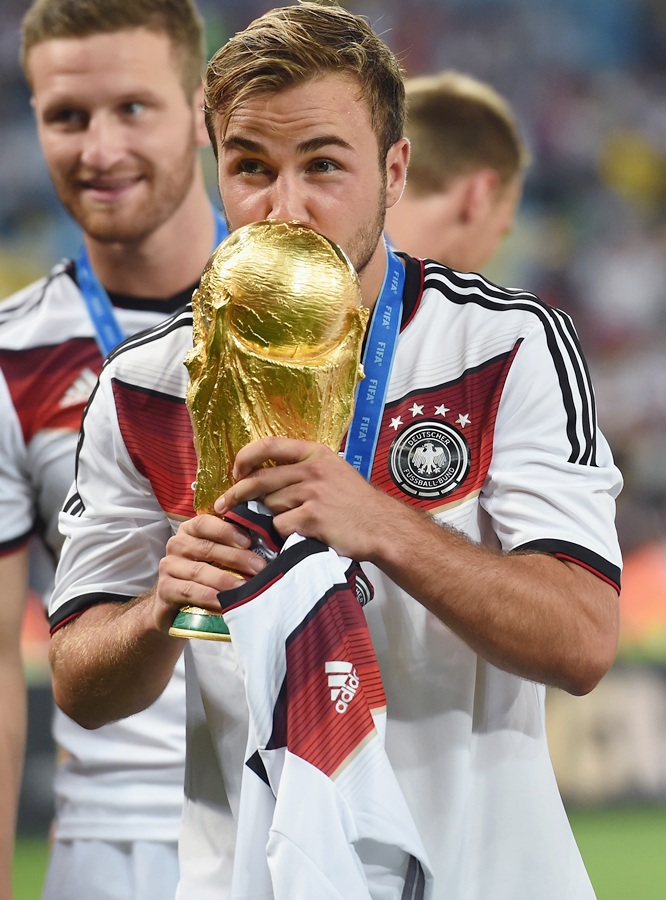 Mario Goetze of Germany kisses the World Cup trophy after defeating Argentina 1-0