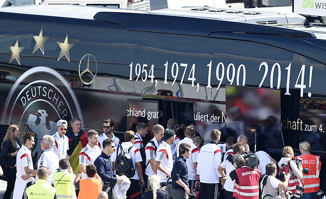 Germany's national soccer team players, winners of the 2014 World Cup, board a bus after their arrival at Tegel airport in Berlin