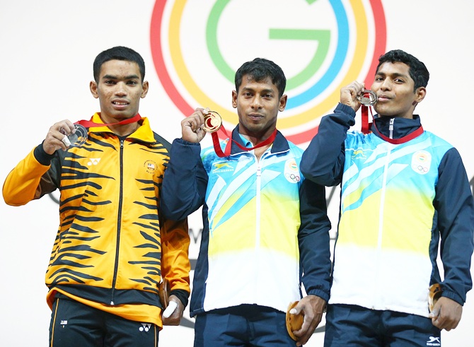 Gold medalist Sanjita Chanu Khumukcham of India (centre), silver medalist Nikechi Opara of Nigeria (right) and bronze medalist Mirabai Chanu Saikhom of India