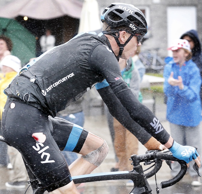 Team Sky rider Christopher Froome of Britain rides in his torn cycling costume after falling in the 5th stage of the Tour de France