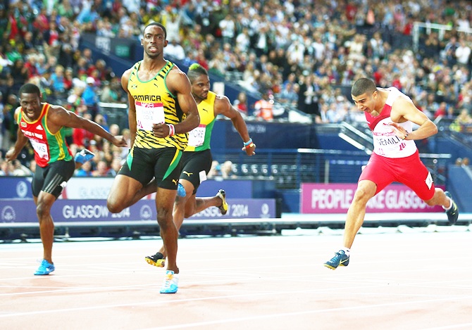 Kemar Bailey-Cole of Jamaica, second right, crosses the line to win gold ahead of silver medalist Adam Gemili of England, right, in the Men's 100 metres final