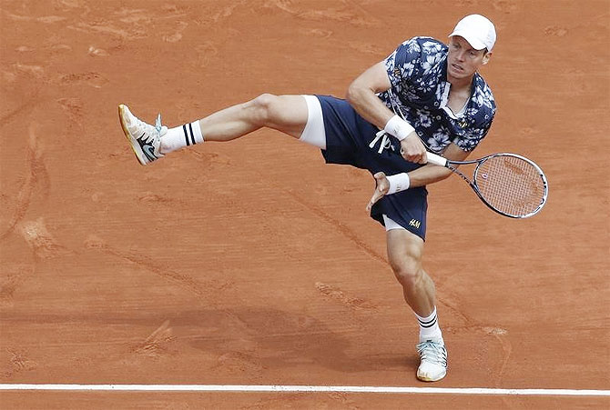 Tomas Berdych of the Czech Republic plays a return against John Isner of the U.S. in their men's singles match at the French Open tennis tournament at the Roland Garros on Sunday