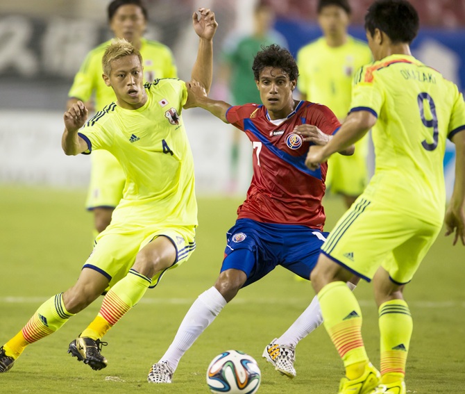 Japan's national soccer team's Keisuke Honda ,left, challenges Costa Rica's Christian Bolanos near Japan's Shinji Okazaki,right, during their international friendly