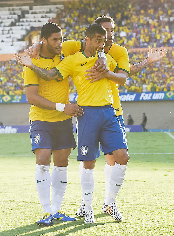 Daniel Alves (centre) of Brazil celebrates with Hulk (left) and Fred after scoring a goal during their international friendly at Serra Dourada Stadium on Tuesday