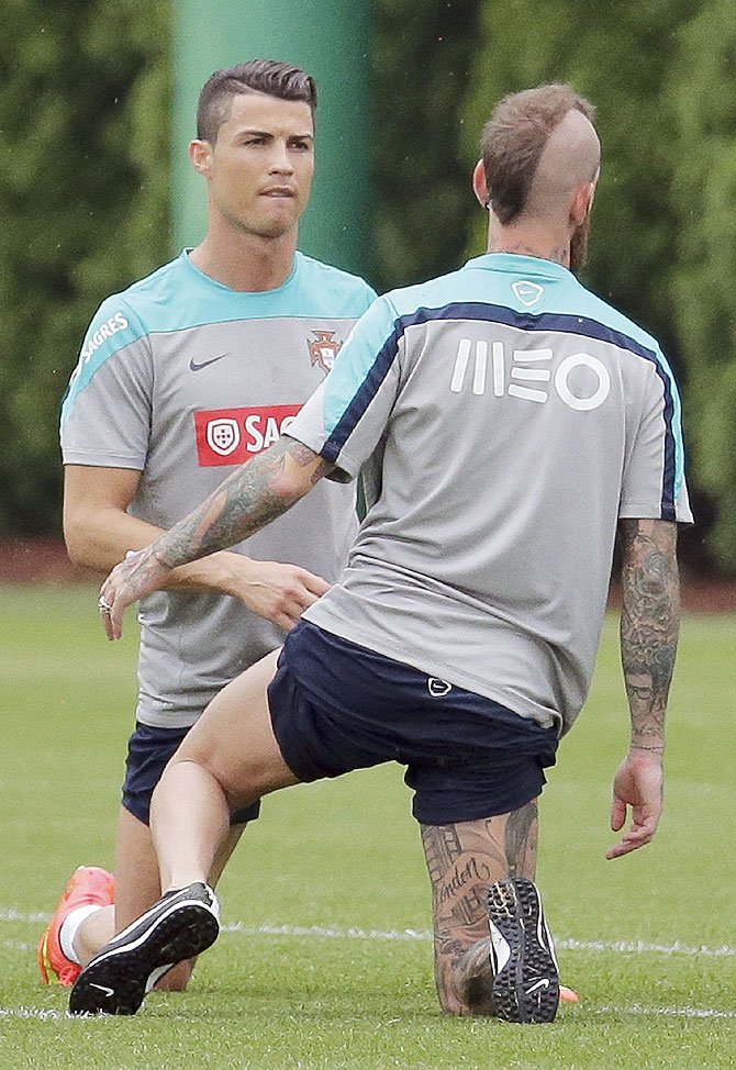Cristiano Ronaldo (left) of Portugal stretches with teammate Raul Meireles as they practice for their upcoming friendly matches in the United States at the NFL New York Jets practice facility in Florham Park, New Jersey, on Tuesday