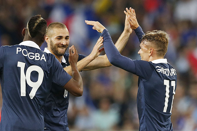 France's Antoine Griezmann (R) celebrates with team mates Paul Pogba (L) and Karim Benzema his goal against Jamaica during their international friendly at Pierre Mauroy Stadium in Villeneuve d'Ascq on Sunday