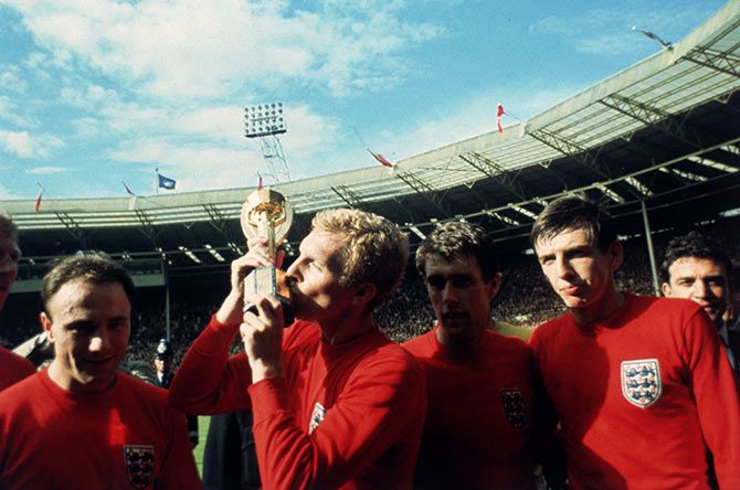 England captain Bobby Moore (centre) kisses the Jules Rimet trophy as the team celebrate winning the 1966 World Cup final against Germany at Wembley Stadium in London