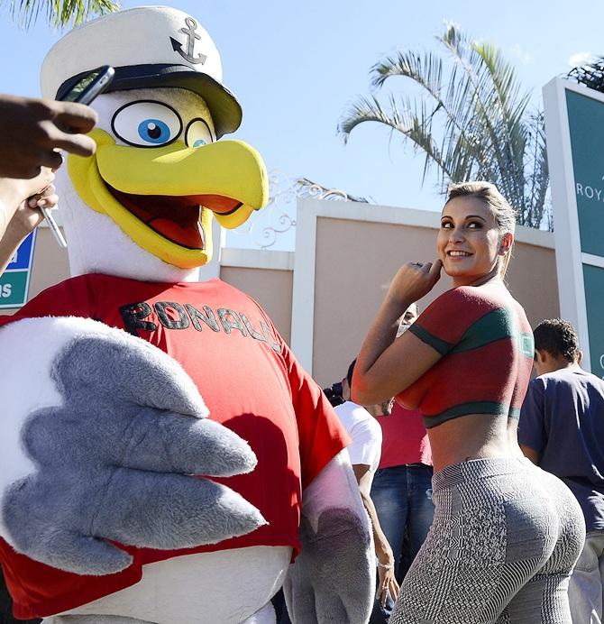 A fan wears a bird costume with the name of Cristiano Ronaldo on the chest poses with Andressa Urach, a Brazilian model and actress who painted her upper body with Portugal's national soccer jersey