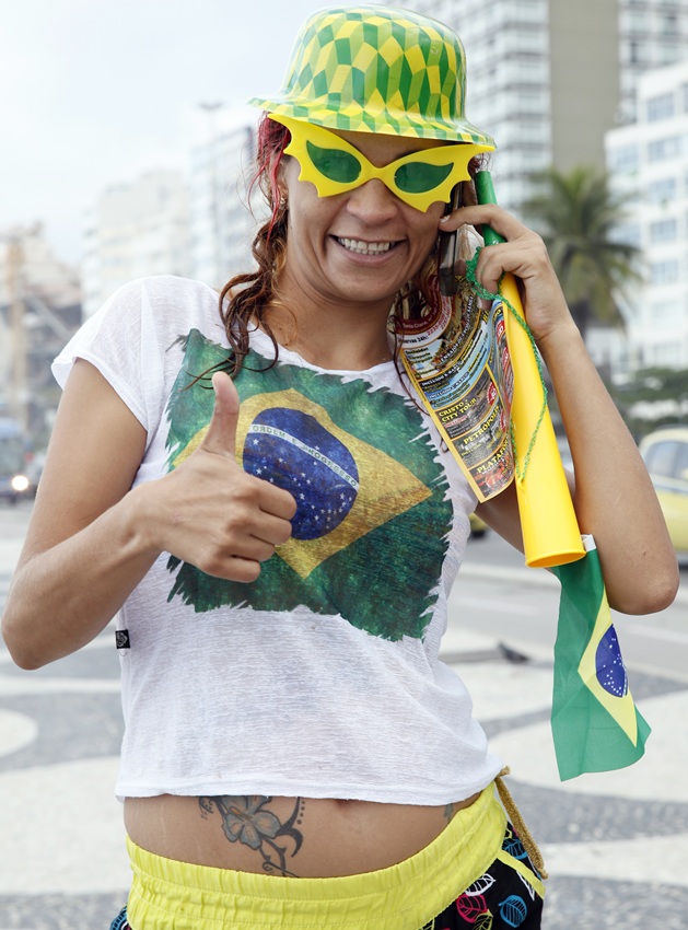 A Brazilian fan gives a thumbs up on Copacabana Beach as the 2014 FIFA World Cup nears