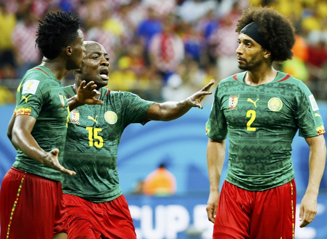 Cameroon's Achille Weboc ,centre, tries to separate teammates Benjamin Moukandjo, left, and Benoit Assou-Ekotto as they argue