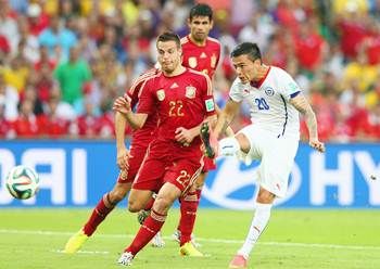 Charles Aranguiz of Chile shoots and scores his team's second goal against Cesar Azpilicueta of Spain