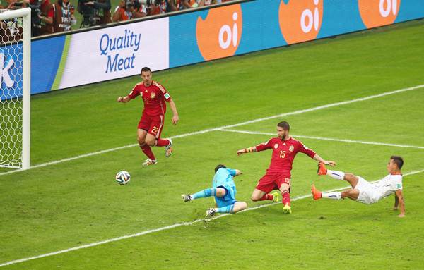 Eduardo Vargas of Chile scores his team's first goal past Sergio Ramos and goalkeeper Iker Casillas