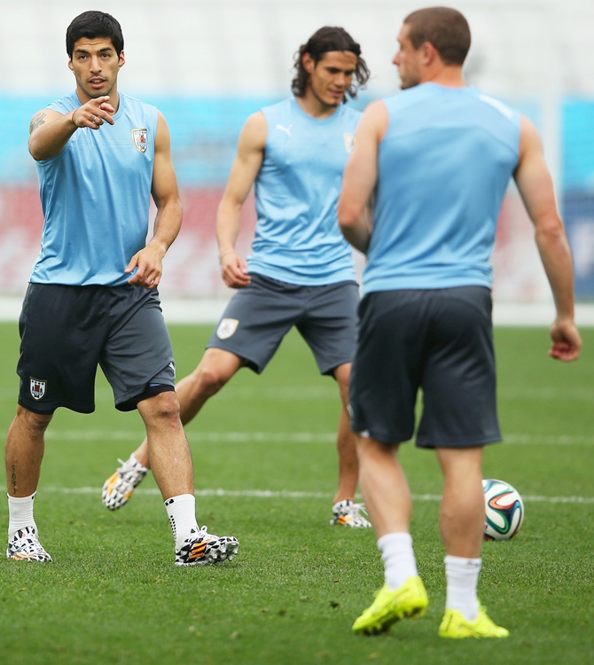 Luis Suarez of Uruguay, left, signals to team mates during a training session
