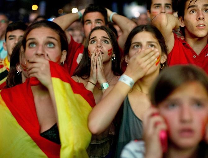 Spanish fans react while watching their team play against the Chileans