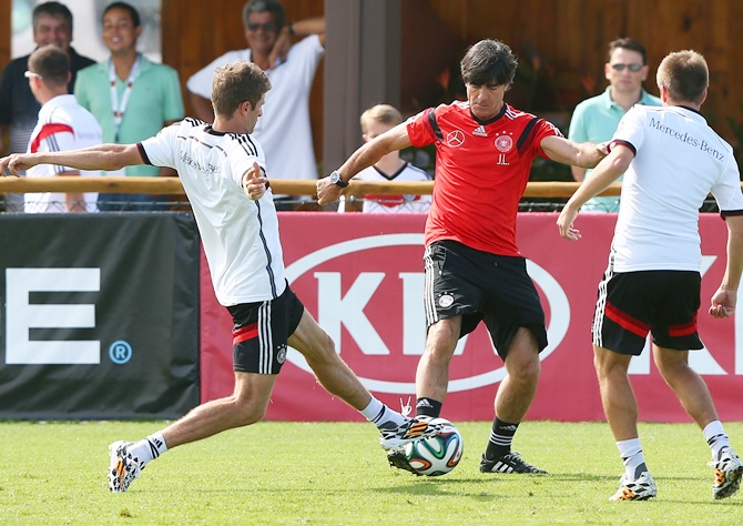 Head cooach Joachim Loew, right, battles for the ball with Thomas Mueller during the training at Campo Bahia