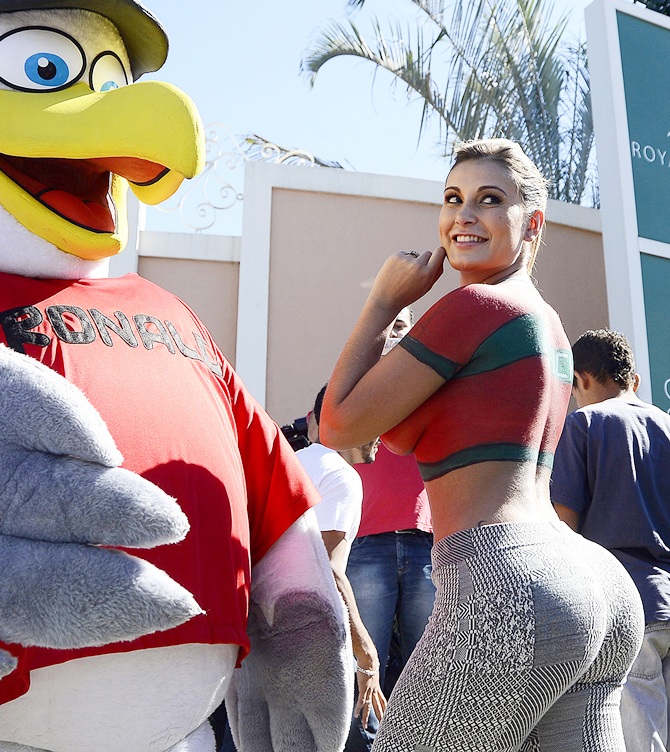A fan wears a bird costume with the name of Cristiano Ronaldo on the chest poses with Andressa Urach, a Brazilian model and actress who painted her upper body with Portugal's national soccer jersey