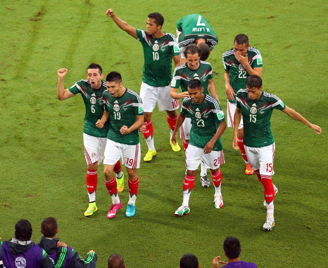 Mexico players celebrate a goal against Cameroon
