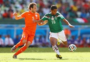 Giovani dos Santos of Mexico beats Daley Blind of the Netherlands to the ball, shoots and scores to put his team into the lead in the World Cup Brazil Round of 16 match.