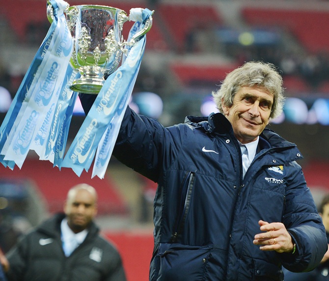 Manuel Pellegrini, manager of Manchester City celebrates victory with the trophy.