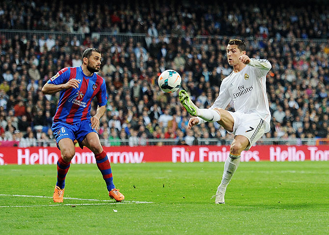 Cristiano Ronaldo (right) of Real Madrid controls the ball as Loukas Vyntra of Levante UD looks on during their La Liga match at Santiago Bernabeu stadium on Sunday