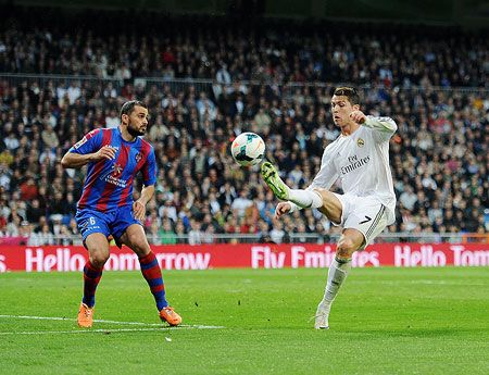 Cristiano Ronaldo (R) of Real Madrid CF controls the ball beside Loukas Vyntra of Levante UD during the La Liga match on Sunday
