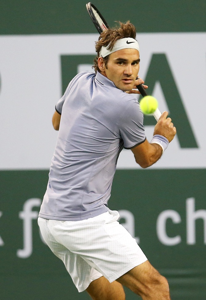Roger Federer of Switzerland hits a return to Tommy Haas of Germany