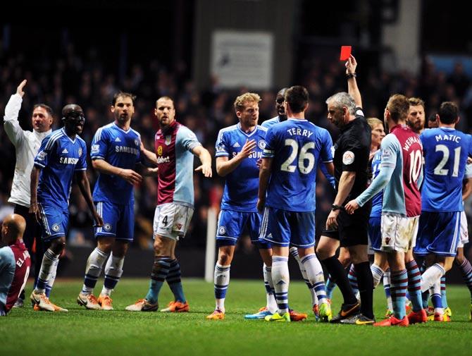 Referee Chris Foy shows Chelsea's Ramires the red card after a challenge on Karim El Ahmadi of Aston Villa.