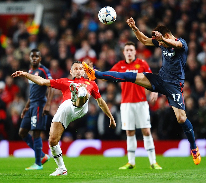 Ryan Giggs of Manchester United competes with Hernan Perez of Olympiacos