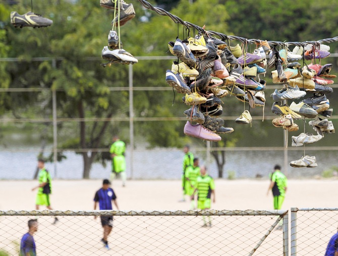 Discarded soccer boots hang from an electric wire where they were thrown by their owners over several months after Sunday 'pelada' soccer matches in the Morro do Papagaio favela in Belo Horizonte, a World Cup host city