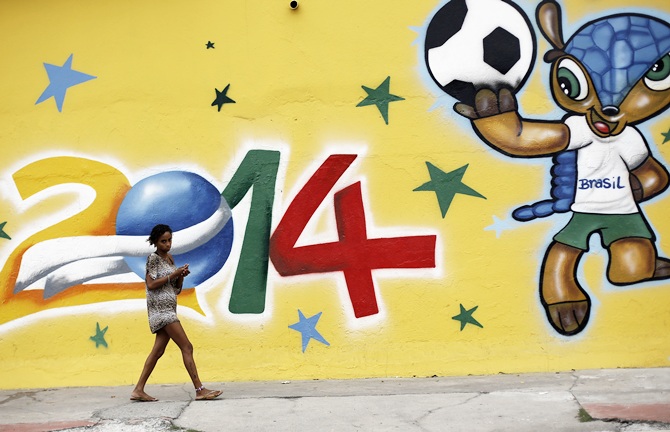 A woman walks past a graffiti painted with the   official mascot of the 2014 World Cup, Fuleco the Armadillo, in Sao Paulo