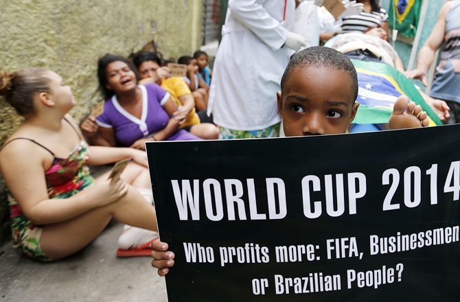 Residents simulate bad service at a public hospital during a protest against the 2014 World Cup