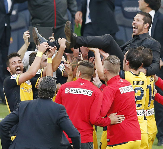 Atletico Madrid's players pick up their coach Diego Pablo Simeone after the team won the La Liga title