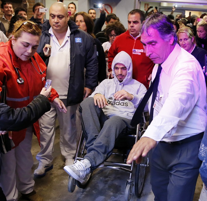 Uruguayan striker Luis Suarez leaves the hospital in a wheel chair after surgery due to a knee injury in Montevideo