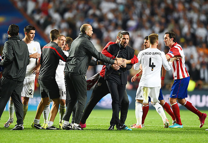 Diego Simeone, Coach of Club Atletico de Madrid is restrained as he clashes with Sergio Ramos of Real Madrid during the UEFA Champions League Final at Estadio da Luz in Lisbon on Saturday