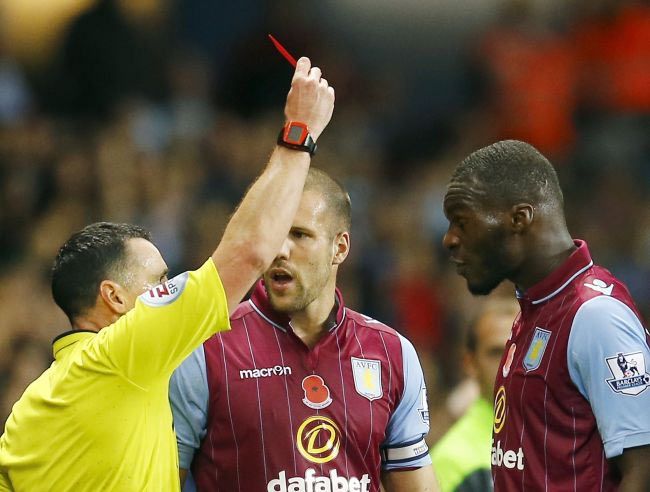 Referee Neil Swarbrick shows Aston Villa's Christian Benteke (R) the red card during their English Premier League match against Tottenham Hotspur at Villa Park