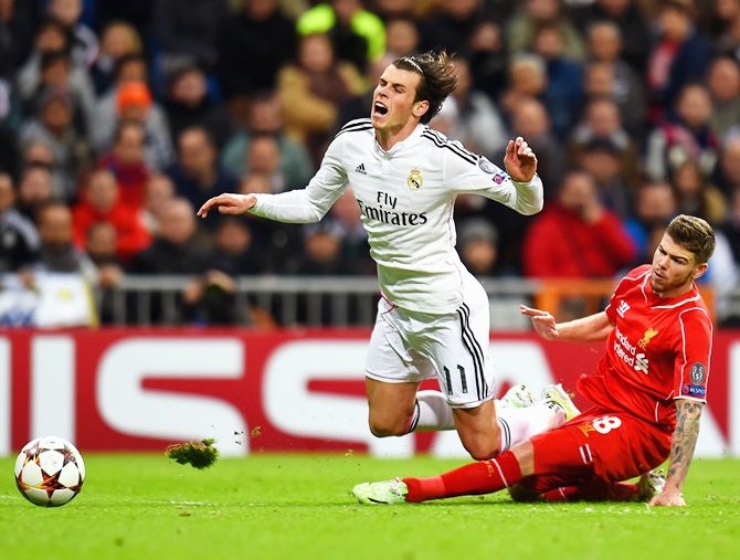 Alberto Moreno of Liverpool tackles Gareth Bale of Real Madrid 