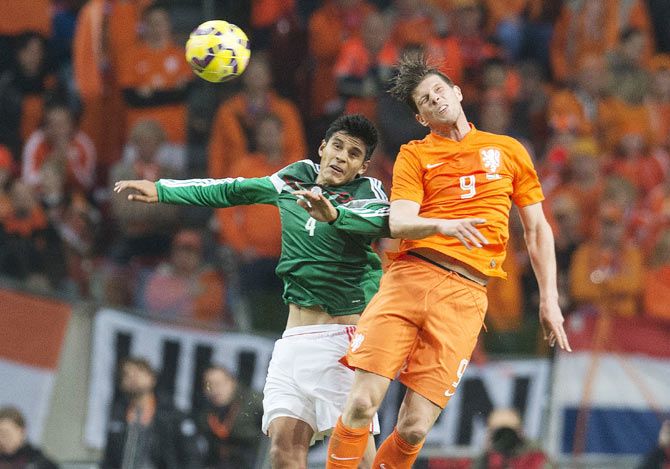 Klaas Jan Huntelaar (R) of the Netherlands challenges Miguel Angel Herrera of Mexico during their international soccer friendly