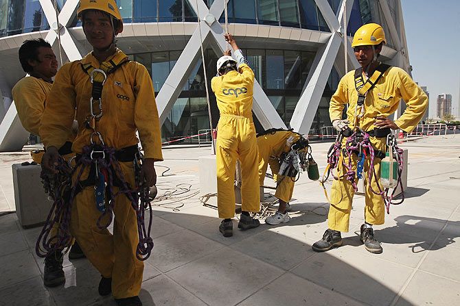 Window washers from Nepal return to ground after working on the curved facade of the Tornado Tower in Doha