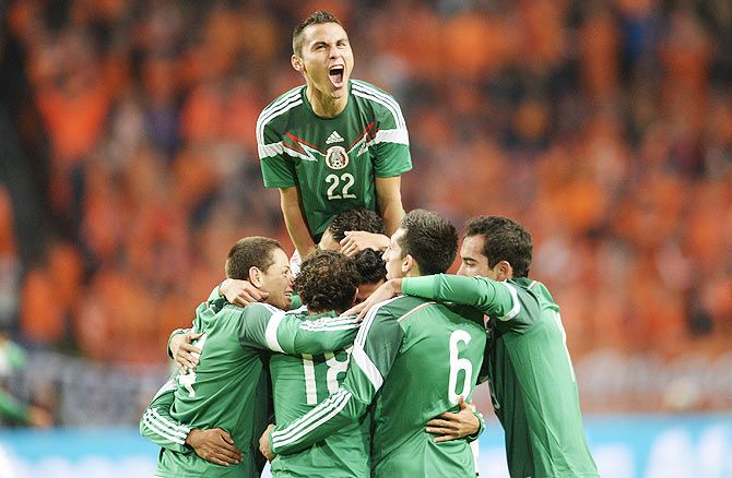 Paul Aguilar (top) of Mexico celebrates a goal against Netherlands on Wednesday
