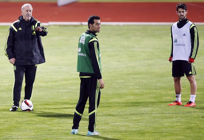 Spain's national coach Vicente del Bosque (left) gives instructions to Sergio Busquets (centre) and Isco during a training session