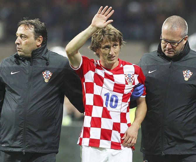 Luka Modric, centre, of Croatia walks off with an injury