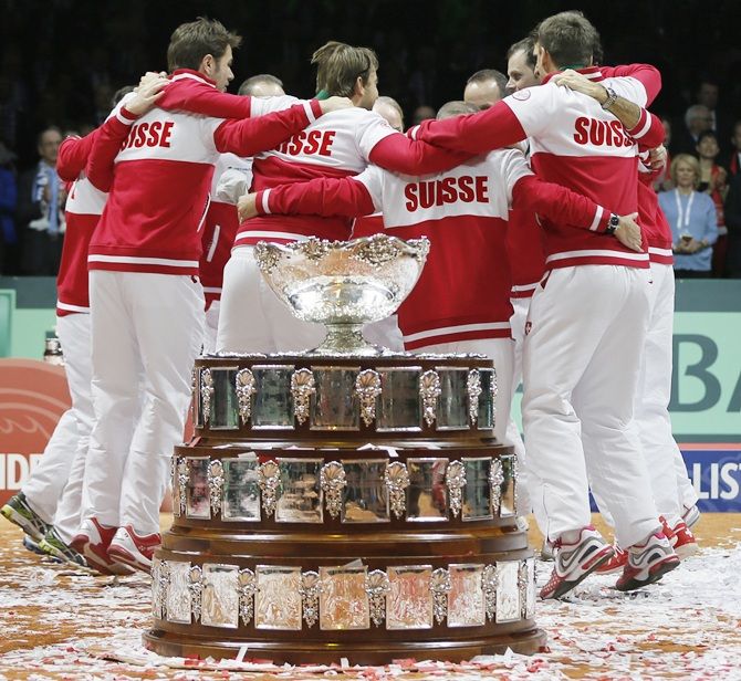 Switzerland's team members celebrate alongside the Davis Cup trophy
