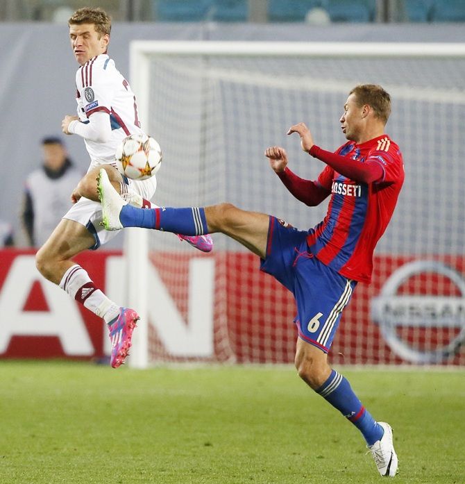 CSKA Moscow's Aleksei Berezutski, right, fights for the ball with Bayern Munich's Thomas Mueller