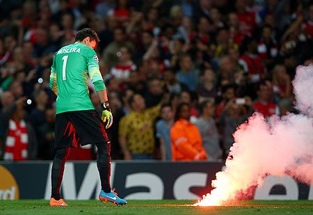 Fernando Muslera of Galatasaray AS carries a flare off the pitch during the UEFA Champions League group D match against Arsenal FC at Emirates Stadium on Tuesday
