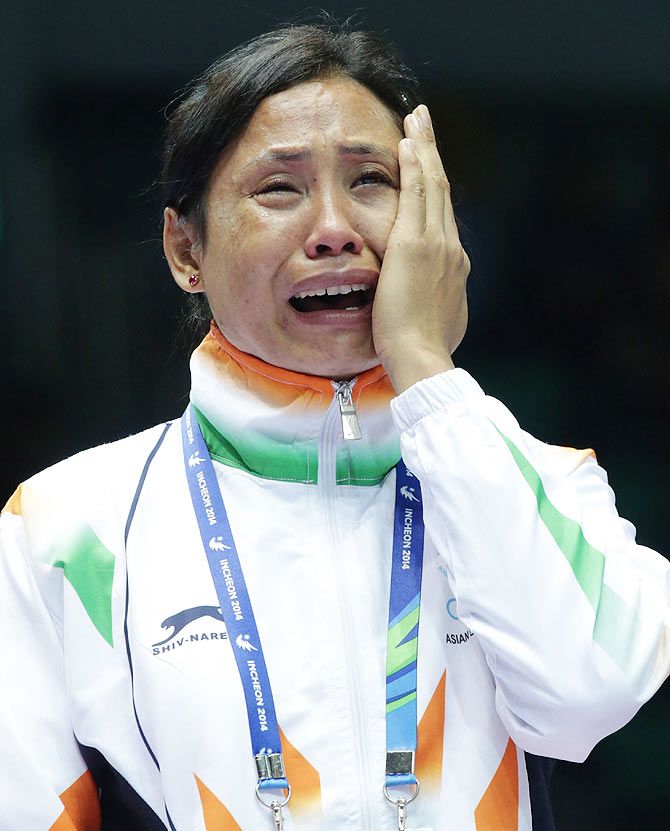 L. Sarita Devi of India cries after she refused her bronze medal during the medal ceremony in the Womens Light Division Final on Wednesday