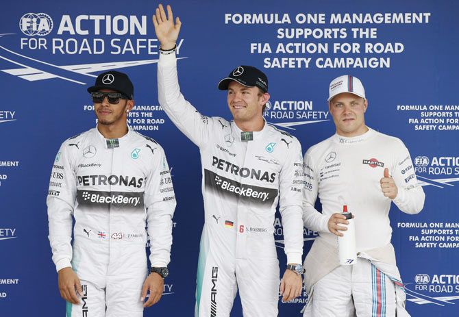 Mercedes Formula One driver Nico Rosberg of Germany, flanked by teammate Lewis Hamilton of Britain (left) and Williams Formula One driver Valtteri Bottas of Finland (right), celebrates after winning pole position in the qualifying session of the Japanese F1 Grand Prix at the Suzuka Circuit on Saturday