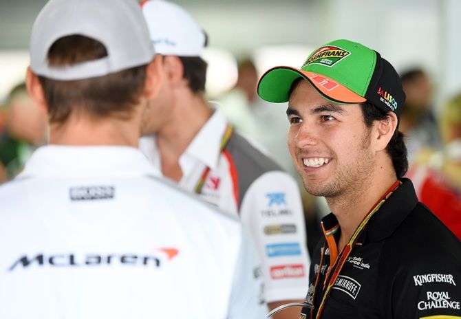 Sergio Perez of Mexico and Force India speaks with Jenson Button