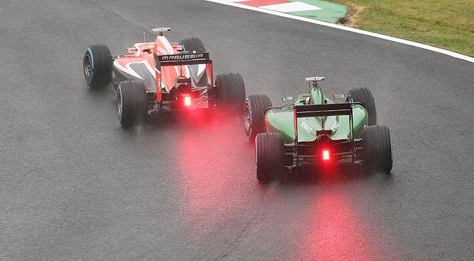 Jules Bianchi of France and Marussia and Romain Grosjean of France and Lotus battle for position during the Japanese Formula One Grand Prix at Suzuka Circuit on October 5