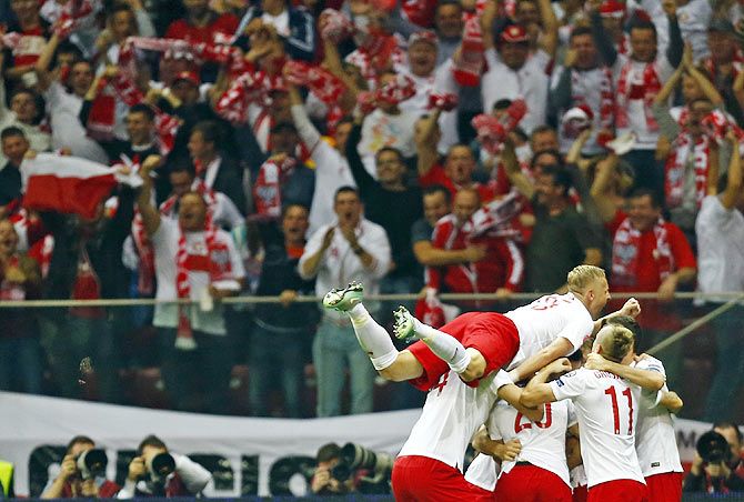 Poland's Arkadiusz Milik (right) celebrates with teammates after scoring against Germany during their Euro 2016 group D qualifying match at the National stadium in Warsaw on Saturday