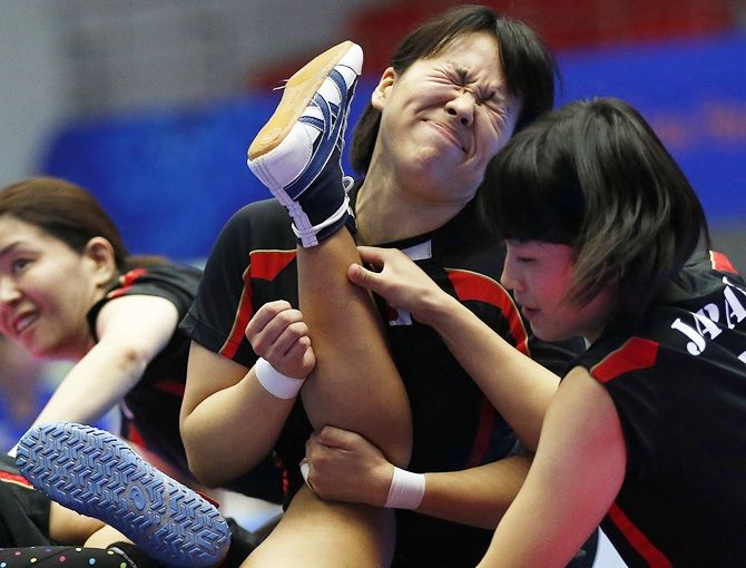 Japan's Yumi Kaneko, Eri Kasahara and Miho Echizenya tackle 